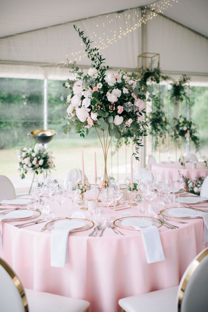 asymetryczna kompozycja kwiatowa na złotym wysokim stojaku na stole gości weselnych