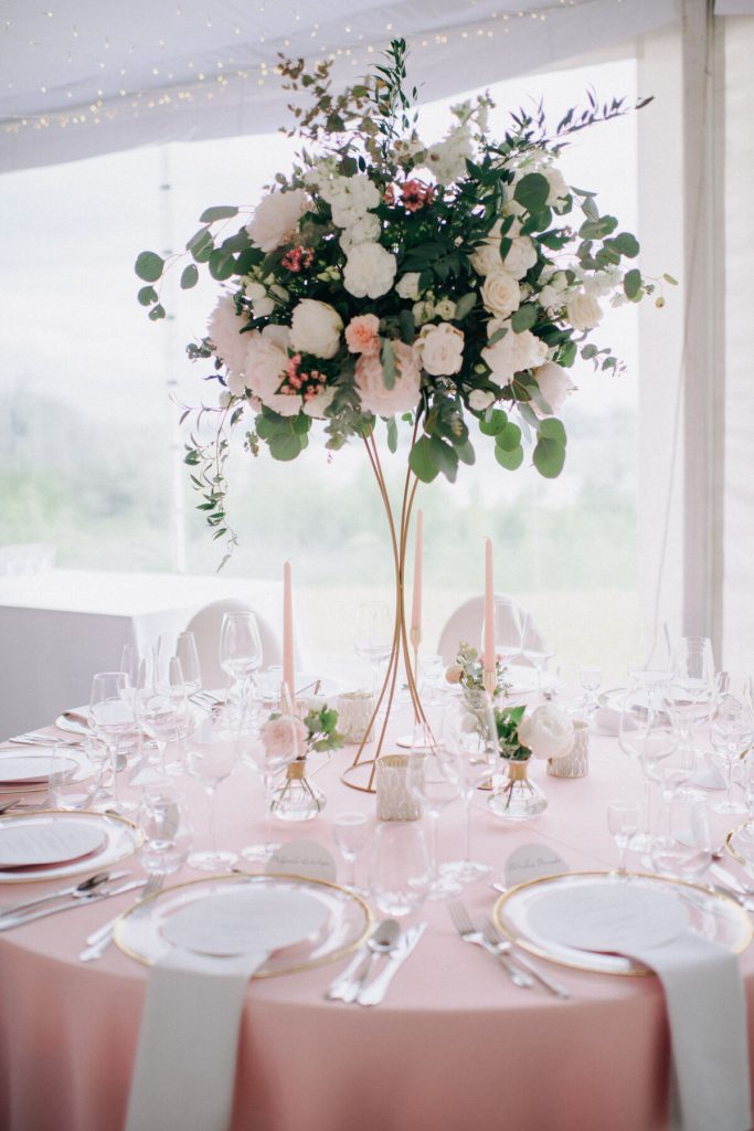 duża kompozycja kwiatowa wraz z dodatkami dekoracyjnymi jako aranżacja stołu gości