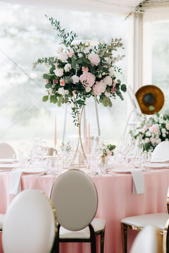 dekoracja stołu gości wysoką kwiatową aranżacją na złotym stojaku