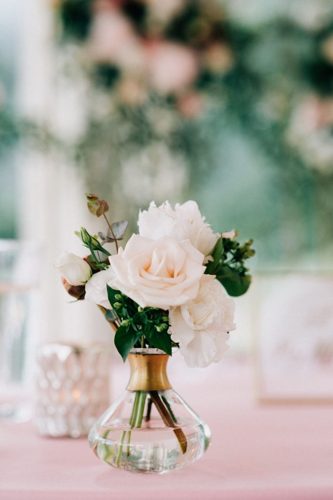 subtelny wazonik kwiatów w pudrowej kolorystyce jako dekoracja wesela