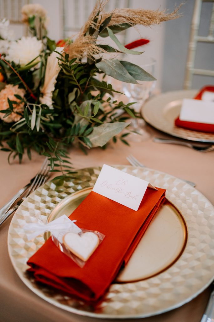serwetki w kolorze ceglastym jako dekoracja nakrycia dla gości weselnych