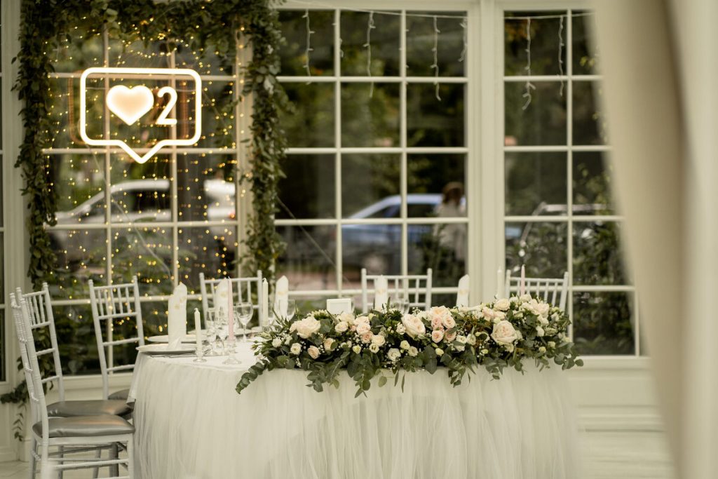 girlanda z eukaliptusa, gipsówki i róż ogrodowych jako dekoracja stołu pary młodej