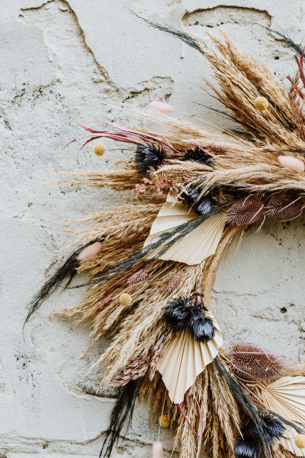 jesienny wianek z suszonych granatowych traw jako dekoracja kominka