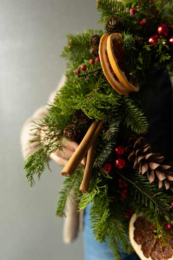 pachnący cynamon i cytrusy jako ozdoby świątecznych wianków